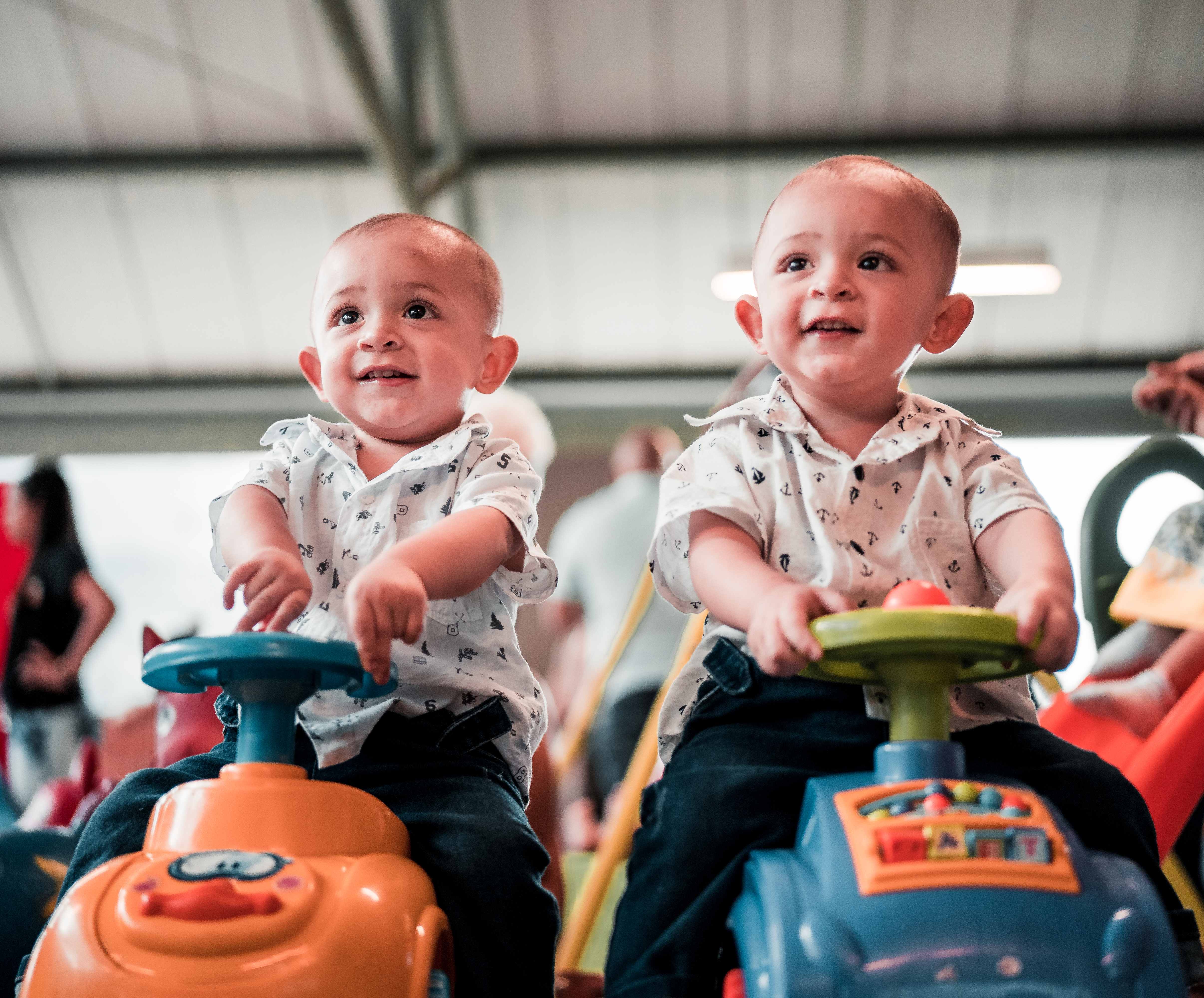 Pic of two twins (boy twins) on toy cars